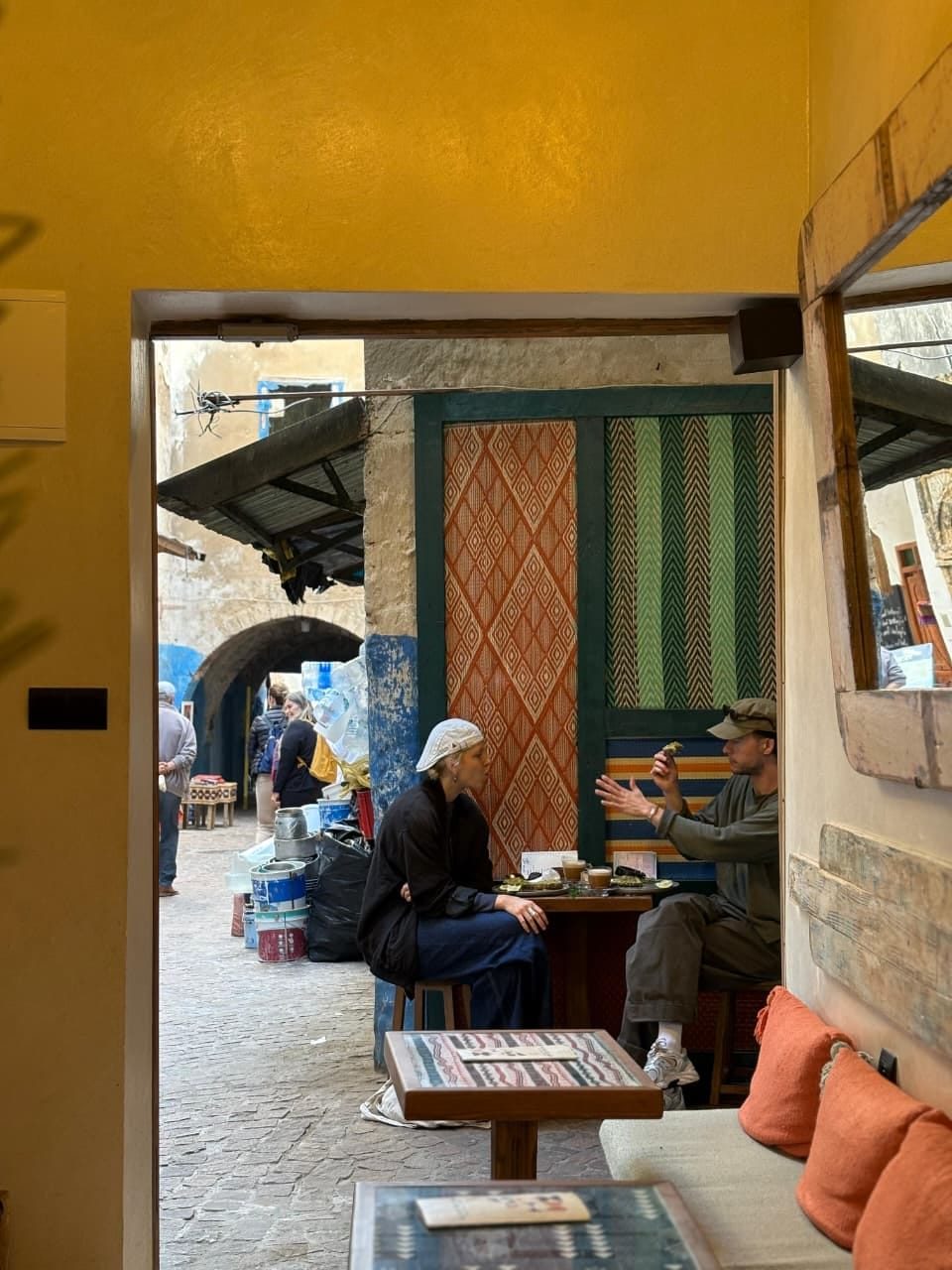 Looking out through Simane's doorway into the medina alley, guests seated just outside