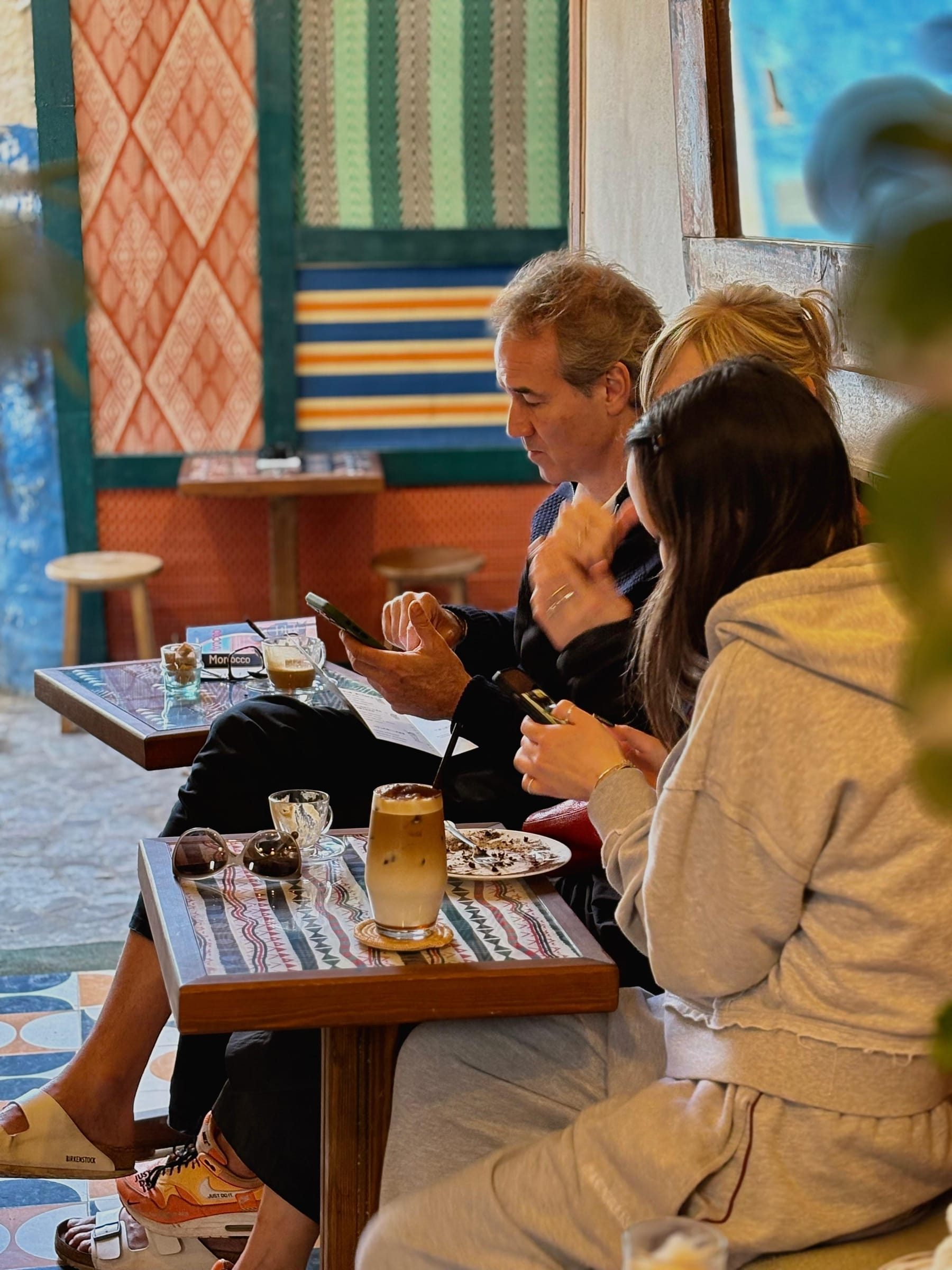 Friends talking over coffee, a Morocco guidebook on the table