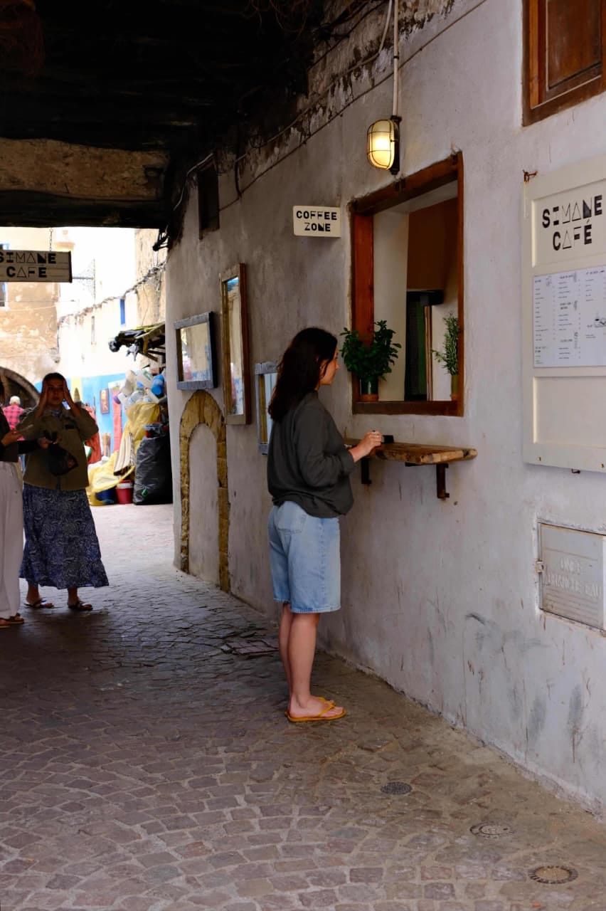 A customer ordering at Simane's take-away window in the Essaouira medina